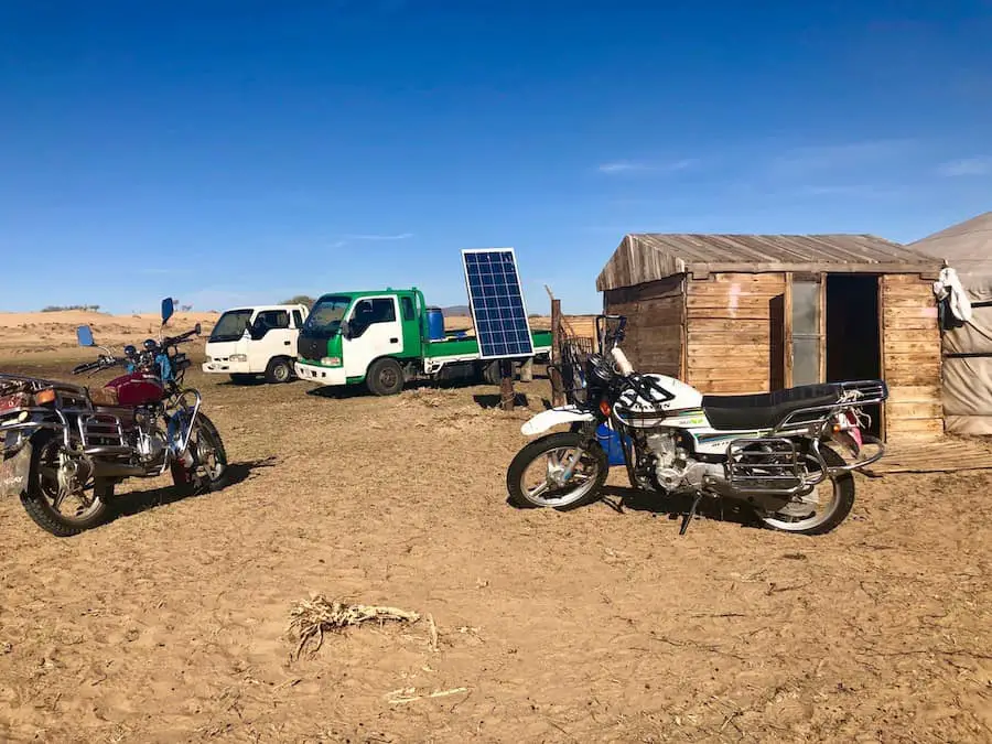 Dirt bikes, solar panels and trucks, Gobi Desert Mongolia. 