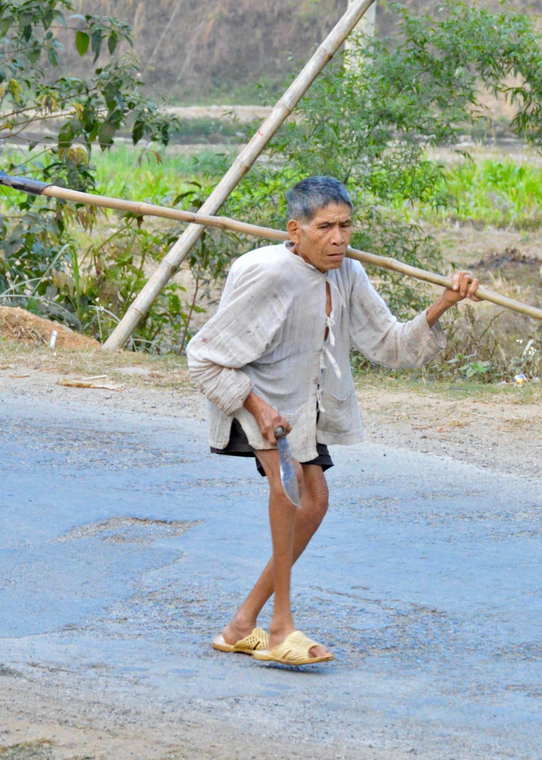 Older man in Vietnam walking down the street.  