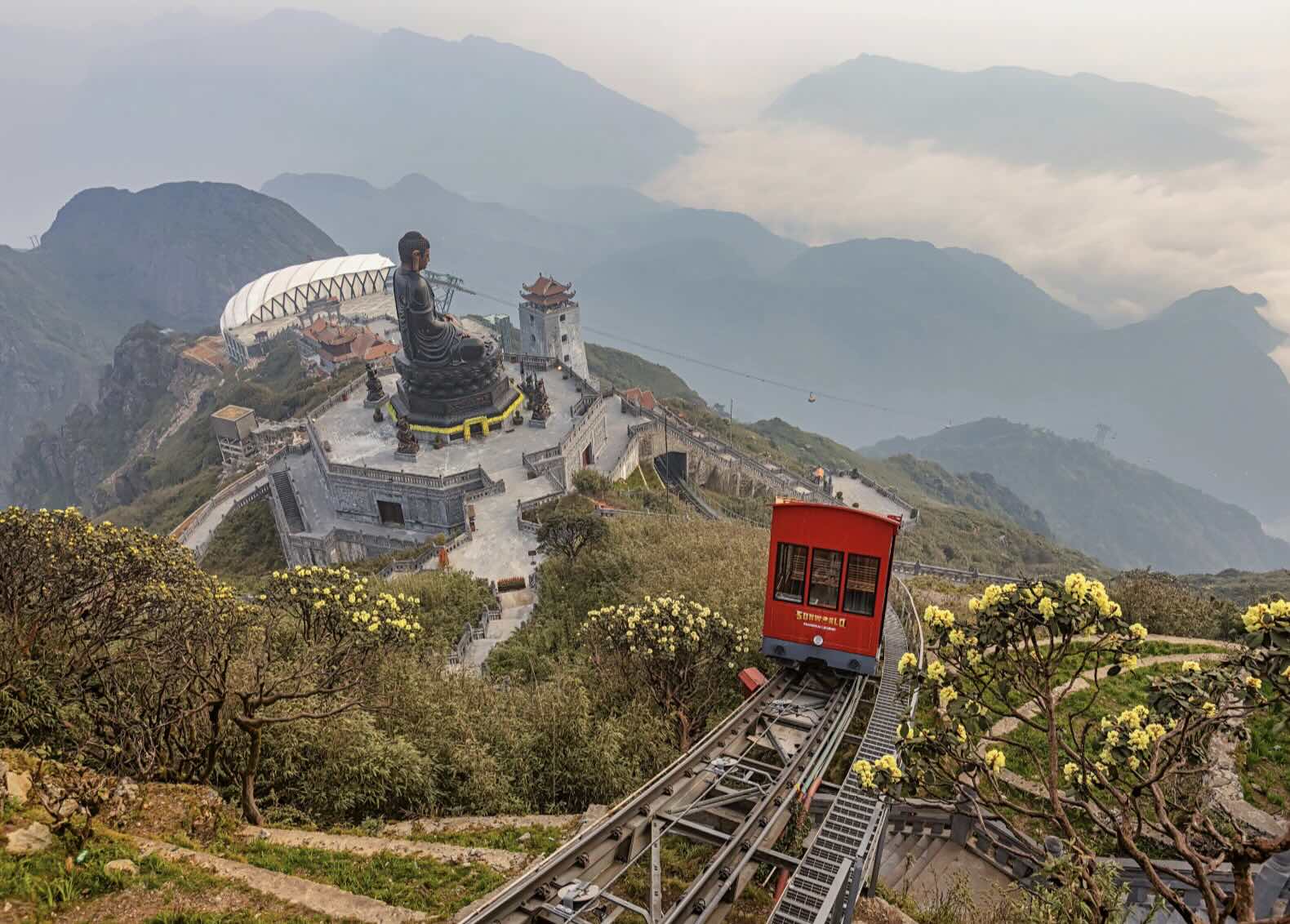 a train going down a hill with a statue on top of it