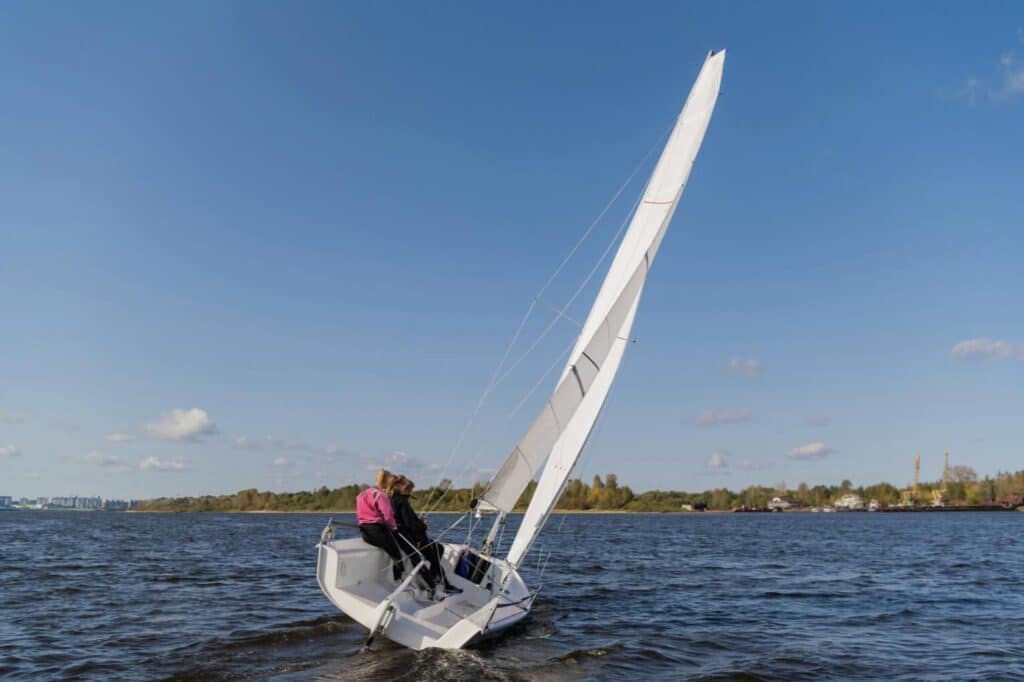 a couple of people on a sailboat in the water