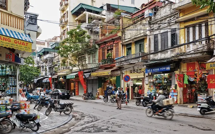 a street with motorcycles and people on it with Thamel in the background